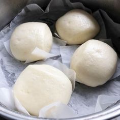 three uncooked doughnuts sitting in a metal bowl