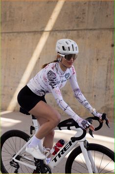 a woman riding a bike down a street