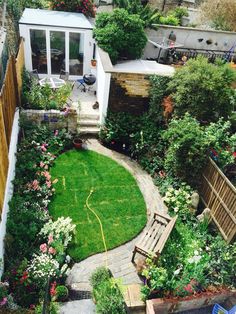 an aerial view of a small backyard with green grass and flowers on the side walk