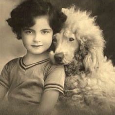 an old black and white photo of a young boy with a dog