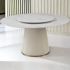 a white table with two plates sitting on it's pedestals in front of a wall