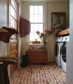 a washer and dryer sitting in a room next to a window filled with flowers