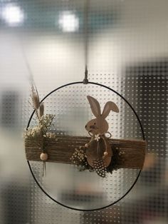 a wooden stick with a bunny on it hanging from the ceiling in front of a window