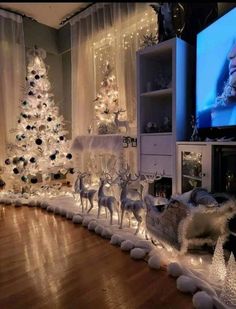 a living room decorated for christmas with white lights and decorations on the walls, along with fake trees