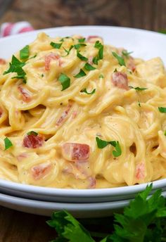 a white bowl filled with macaroni and cheese on top of a wooden table