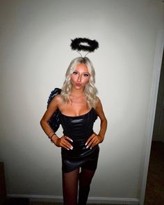 a woman in a black dress is posing with her hands on her hips while wearing a cat costume