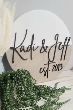 a sign that says kadi & gift est 2013 on it next to some green plants