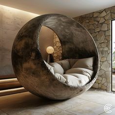 a large round bed sitting in the middle of a room next to a stone wall