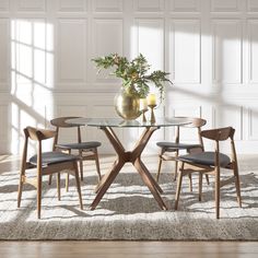 a glass table with chairs around it in front of a white paneled wall and floor