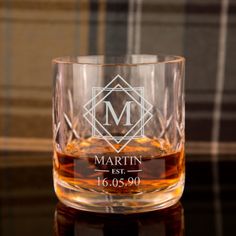 a personalized whiskey glass sitting on top of a table