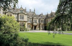 a large building with lots of windows in front of trees and grass on the ground