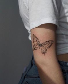 a small butterfly tattoo on the left upper arm and lower arm, is shown in black ink