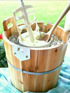 a wooden bucket filled with ice cream on top of a blanket