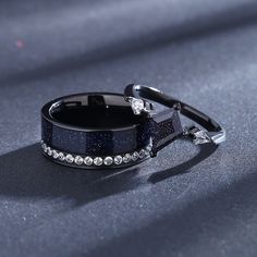 a couple of black rings sitting on top of a table next to each other,