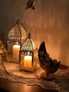 three lit candles sitting on top of a table next to other decorative objects and decorations