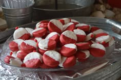 red and white heart shaped marshmallows are on a silver platter next to other baking utensils