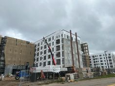 a large building under construction with scaffolding on the front and side walls, next to a street