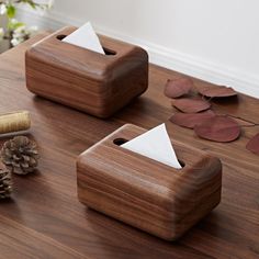 two wooden tissue dispensers sitting on top of a table