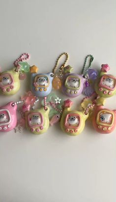 a bunch of little toys that are sitting on a table together with key chains attached to them