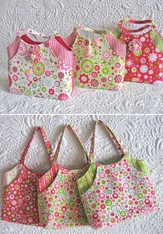 four bags are lined up on the bed, one is pink and green with flowers