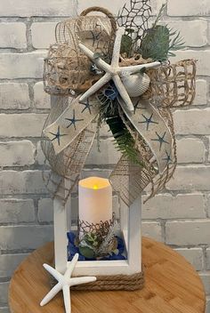 a white candle sitting on top of a wooden table next to a starfish decoration