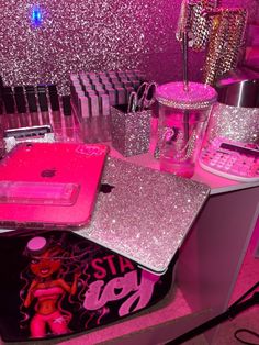 a desk with pink glitter on it and various items