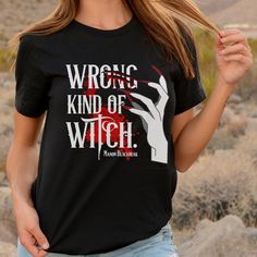 a woman wearing a black t - shirt with the words wrong kind of witch on it