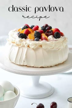 a cake with fruit on top and the words classic pavlova recipe above it