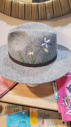 Beautiful soft gray felted fedora hat. Hand embroidered flora and fauna design stitches into the crown of the hat.  22 inches inside the crown with adjustable ribbon option.  Faux leather strap, removable.  One size fits most. Adjustable Brimmed Gray Felt Hat, Adjustable Gray Brimmed Felt Hat, Gray Brimmed Fedora For Spring, Gray Short Brim Fedora For Spring, Gray Adjustable Flat Brim Fedora, Adjustable Brimmed Felt Hat For Spring, Adjustable Short Brim Felt Hat For Spring, Gray Wide Brim Felt Hat With Adjustable Fit, Adjustable Gray Felt Hat For Fall