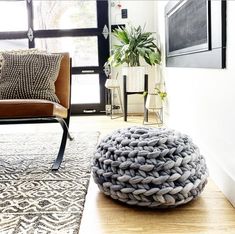 a chair and ottoman in a room with a rug on the floor next to it