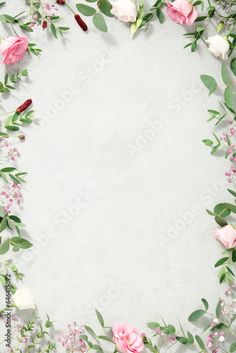 a white background with pink roses and green leaves on it's edges is surrounded by greenery