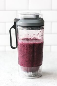 a blender filled with purple liquid on top of a counter