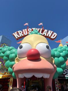 the entrance to krussyland amusement park with an over - sized clown head