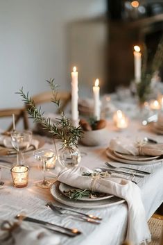 the table is set with silverware, candles and napkins for an elegant dinner