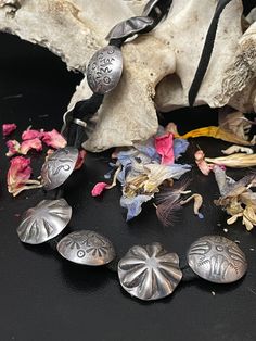 several metal objects sitting on top of a table next to dried flowers and other items