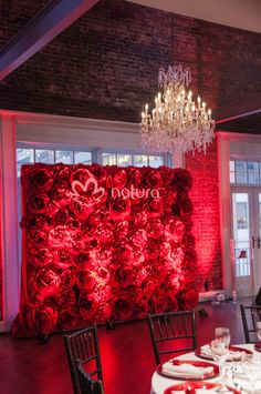 a room with red roses on the wall and chandelier hanging from the ceiling