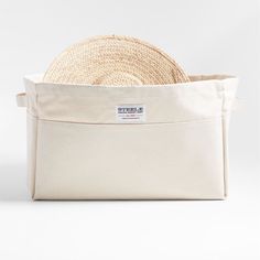 a straw hat in a canvas bag on a white background with the label's name