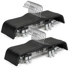 three black plastic hangers with clips attached to them