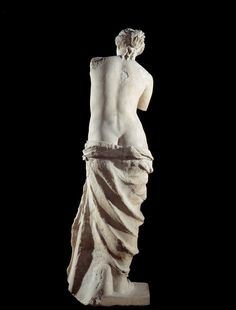 the back view of a marble statue of a woman with her hands on her hips