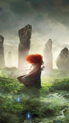 a woman with red hair standing in the middle of a field next to large rocks