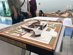 some people are standing around a model of a building