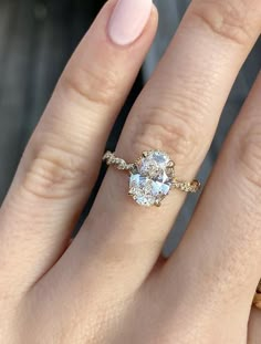 a woman's hand with a ring on it and an oval diamond in the middle