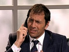 a man in a suit talking on a cell phone