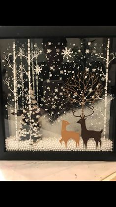 an image of two deer in the snow with trees and snowflakes behind it