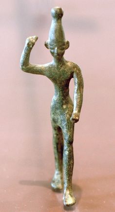 an old bronze figurine with a hat on it's head and arms in the shape of a man