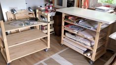 there are many shelves in the kitchen with magazines on them and other items around it