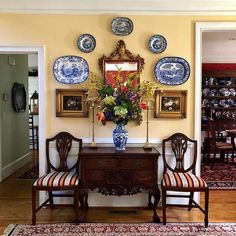 a dining room table with chairs and plates on the wall