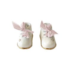 Description Celebrate the joyous arrival of a precious newborn with our exquisitely crafted ceramic baby booties. Each pair is delicately cast and carefully glazed to mimic the adorable shape of traditional baby shoes, & adorned with 22K gold details by skilled Ruby Clay artisans. These make for a thoughtful gift and precious addition to a nursery. With customizable options available, including name, birthdate and size, you can create a truly one-of-a-kind memento that will be treasured for a li Ginger Jar Lamp, Ceramic Supplies, Studio Bag, Ceramic Shop, Baby Booties, Blue Ribbon, Ceramic Artists, Keepsake Gift, 22k Gold