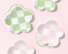 four green and white checkered paper plates on a pink surface with the words cake baked flower tins