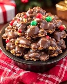 chocolate covered cookies on a black plate with christmas decorations in the backgroung